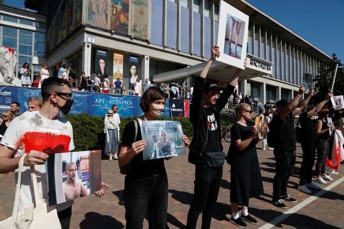 Demonstranti v Misku drží fotografie jako důkaz o policejní brutalitě vůči protestujícím.