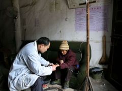 Lékař aplikuje nitrožilní léčbu v jedné malé klinice na čínském venkově. Oproti rozvinutým obchodním a průmyslovým oblastem je venkov nelidnatější země značně zaostalý