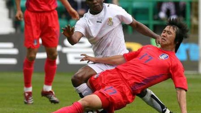 Ghanský fotbalista Matthew Amoah (v bílém) v souboji s Korejcem Lee Ho v přípravném zápase Ghana - Jižní Korea.