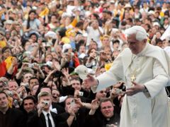 Papež se zdraví s účastníky mše na fotbalovém stadionu.