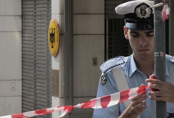 A traffic policeman places a police line outside the German embassy in Athens October 9, 2012. Merkel arrived in Greece on her first visit since Europe's debt crisis erupted here three years ago, braving protests to deliver a message of support - but no new money - to a nation hammered by recession and fighting to stay in the Euro. About 6,000 policemen will be deployed in the capital for her six hour visit, turning the city centre into a no-go zone for protest marches planned by labour unions and opposition parties. REUTERS/Costas Baltas/ICON (GREECE - Tags: CIVIL UNREST POLITICS BUSINESS) GREECE OUT. NO COMMERCIAL OR EDITORIAL SALES IN GREECE Published: Říj. 9, 2012, 11:55 dop.