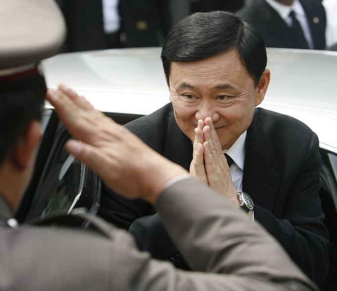 Thaksin před budovou Nejvyššího soudu zdraví stráž tradičním thajským gestem wai, vyjadřujícím respekt i absenci zlých úmyslů. Ne všichni mu demonstrovanou pokoru věří