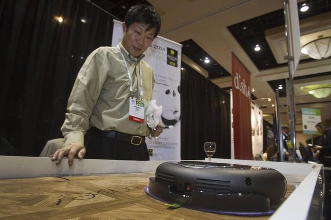 Jong Soo Kim gives a demonstration of Moneual's Rydis H68 Pro Hybrid Robot Vacuum during &quot;CES Unveiled,&quot; a media preview event to the annual Consumer Electronic