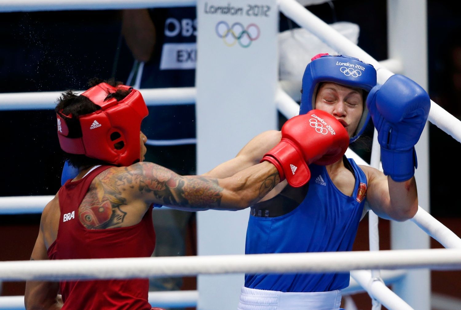 Brazilská boxerka Adriana Arujová zápasí s Ruskou Sofyou Očigavovou na OH 2012 v Londýně.