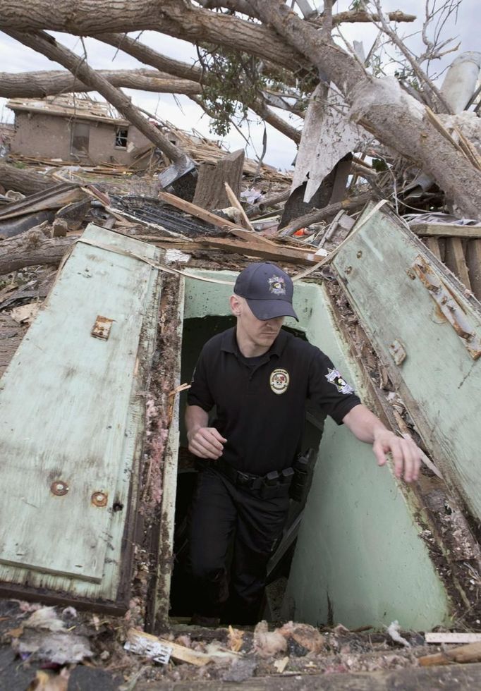 Oklahoma County Sheriff's Deputy Erik Gransberg searches for victims in an underground shelter in Moore, Oklahoma May 21, 2013. Rescuers went building to building in search of victims and thousands of survivors were homeless on Tuesday, a day after a massive tornado tore through a suburb of Oklahoma City, wiping out whole blocks of homes and killing at least 24 people. REUTERS/Richard Rowe (UNITED STATES - Tags: DISASTER ENVIRONMENT) Published: Kvě. 21, 2013, 11:43 odp.