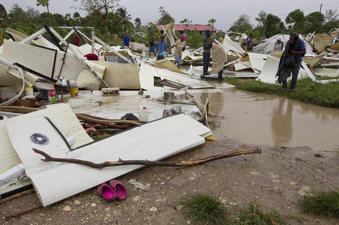 Residents survey the damage to their homes in a camp for displaced people in a low lying area of Port-Au-Prince, August 25, 2012. Tropical Storm Isaac emerged over warm Caribbean waters on Saturday slightly weaker but ready to regroup after dumping torrential rains on Haiti, where thousands of people remain homeless more than two years after a devastating earthquake. REUTERS/UN/MINUSTAH/Logan Abassi/Handout (HAITI - Tags: DISASTER ENVIRONMENT) FOR EDITORIAL USE ONLY. NOT FOR SALE FOR MARKETING OR ADVERTISING CAMPAIGNS. THIS IMAGE HAS BEEN SUPPLIED BY A THIRD PARTY. IT IS DISTRIBUTED, EXACTLY AS RECEIVED BY REUTERS, AS A SERVICE TO CLIENTS Published: Srp. 25, 2012, 4:13 odp.