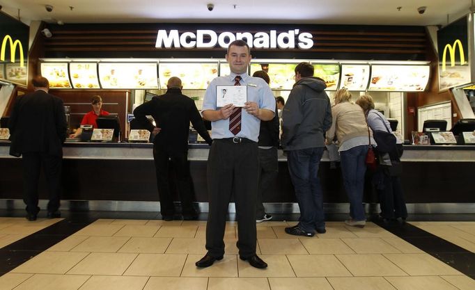 Marcin Lubowicki, a 28 year-old deputy manager of a McDonald's restaurant, poses with his university diploma in front of the fast food chain in the Arkadia shopping mall, Warsaw May 16, 2012. Lubowicki, who has degree in Russian language from Warsaw University, has been working for McDonald's since 2007. He is planning to stay in his job.