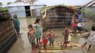 BANGLADESH-FLOODS/ Description: Children stand on a makeshift banana plant raft in front of their house at a flooded village in Kurigram July 3, 2012. At least 100 people have died and hundreds of thousands of people are marooned as floods triggered by heavy rains spread across Bangladesh. REUTERS/Andrew Biraj (BANGLADESH - Tags: DISASTER ENVIRONMENT) Published: Čec. 3, 2012, 10:16 dop.