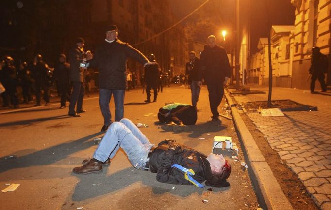 Muž leží na ulici v Kyjevě po zásahu policie proti demonstrantům