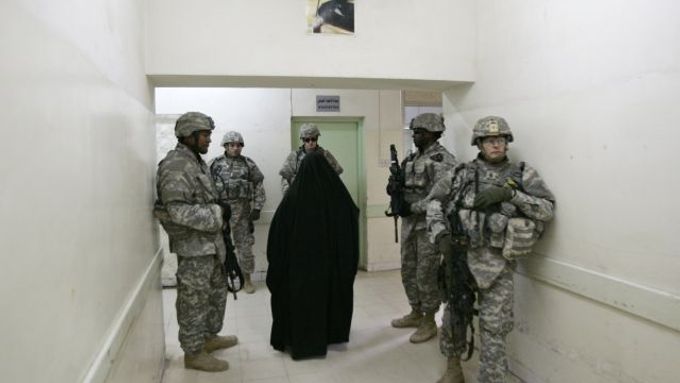 Irácká žena prochází v bagdádské nemocnici kolem amerických vojáků.