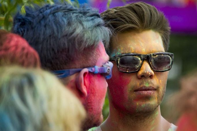 Revellers are covered in pigment powder during the Holi festival in Berlin, July 29, 2012. Holi, also known as the festival of colours, is a festival celebrated in India and other Hindu countries that in its original form heralds the beginning of spring. The Berlin event brought Indian Djs, acrobatics and dance to the German capital. REUTERS/Thomas Peter (GERMANY - Tags: SOCIETY) Published: Čec. 29, 2012, 4:12 odp.