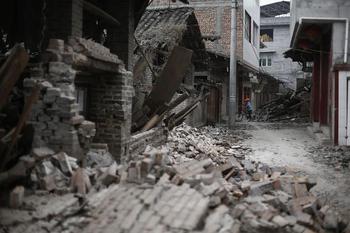 A boy rides a bicycle among debris after Saturday's earthquake in Lushan county, April 22, 2013. Rescuers struggled to reach a remote, rural corner of southwestern China on Sunday as the toll of the dead and missing from the country's worst earthquake in three years climbed to 208 with almost 1,000 serious injuries. The 6.6 magnitude quake struck in Lushan county, near the city of Ya'an in the southwestern province of Sichuan, close to where a devastating 7.9 quake hit in May 2008, killing 70,000. REUTERS/Aly Song (CHINA - Tags: DISASTER SOCIETY) Published: Dub. 22, 2013, 3:48 dop.