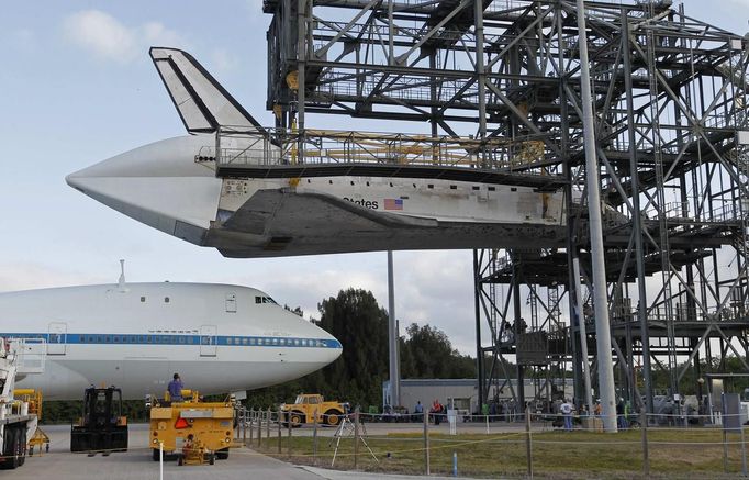 The space shuttle Discovery is approached by a NASA 747 aircraft which was towed into the Mate Demate facility, at Kennedy Space Center in Cape Canaveral