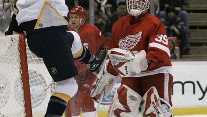 Brnakář Dominik Hašek z Detroitu sleduje, jak se nashvillský obránce Greg Zanon raduje z gólu v jeho brance.