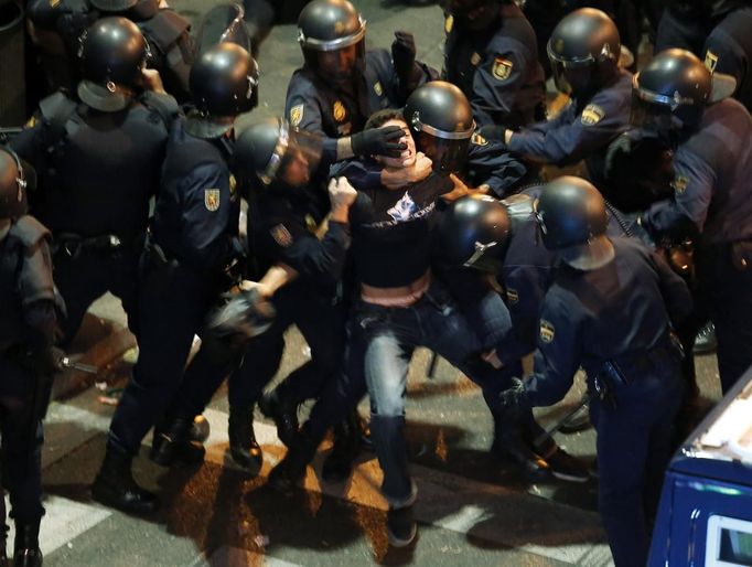 A demonstrator struggles with Spanish National Police riot officers outside the the Spanish parliament in Madrid September 25, 2012. Protesters clashed with police in Spain's capital on Tuesday as the government prepares a new round of unpopular austerity measures for the 2013 budget that will be announced on Thursday. REUTERS/Sergio Perez (SPAIN - Tags: CIVIL UNREST POLITICS BUSINESS TPX IMAGES OF THE DAY) Published: Zář. 25, 2012, 6:50 odp.