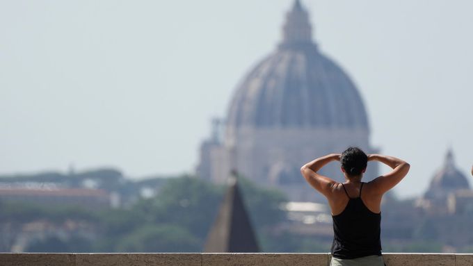 Žena pozoruje chrám Svatého Petra v Římě. Hlavní město Itálie zasáhly teploty kolem 40 stupňů Celsia, platí nejvyšší stupeň varování před horkem.