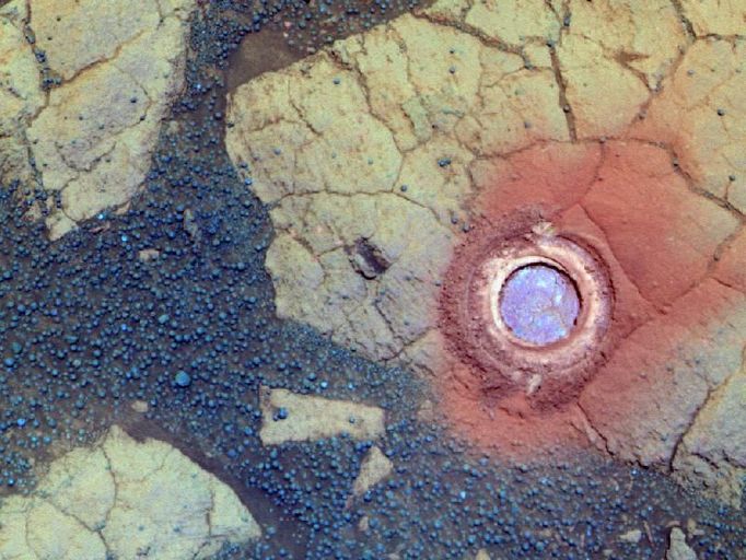 Gagarin' Rock Examined by Opportunity in 2005, False Color NASA's Mars Exploration Rover Opportunity used its rock abrasion tool on a rock informally named "Gagarin" during the 401st and 402nd Martian days, or sols, of the rover's work on Mars (March 10 and 11, 2005). This false-color image shows the circular mark created where the tool exposed the interior of the rock Gagarin at a target called "Yuri." The circle is about 4.5 centimeters (1.8 inches) in diameter. Gagarin is at the edge of a highly eroded, small crater that was informally named "Vostok" for the spacecraft that carried Cosmonaut Yuri Gagarin in the first human spaceflight, on April 12, 1961. This image combines exposures taken through three different filters by Opportunity's panoramic camera on Sol 405 (March 14, 2005). The view is presented in false color to emphasize differences among materials in the rocks and the soils. Images showing the context for the location of Vostok crater are at http://photojournal.jpl.nasa.gov/catalog/PIA07193 and http://photojournal.jpl.nasa.gov/catalog/PIA07471. NASA's Jet Propulsion Laboratory, a division of the California Institute of Technology in Pasadena, manages the Mars Exploration Rover Project for the NASA Science Mission Directorate, Washington. Image credit: NASA/JPL-Caltech/Cornell Univ./ASU