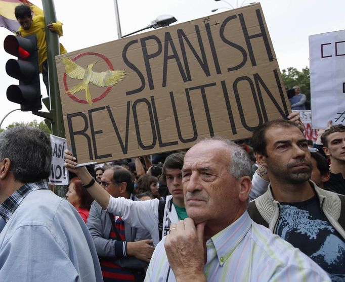 Anti-austerity demonstrators carry a placard as they protest outside the the Spanish parliament in Madrid, September 25, 2012. Protesters clashed with police in Spain's capital on Tuesday as the government prepared a new round of unpopular austerity measures for the 2013 budget to be announced on Thursday. REUTERS/Paul Hanna (SPAIN - Tags: POLITICS CIVIL UNREST BUSINESS) Published: Zář. 25, 2012, 11:20 odp.