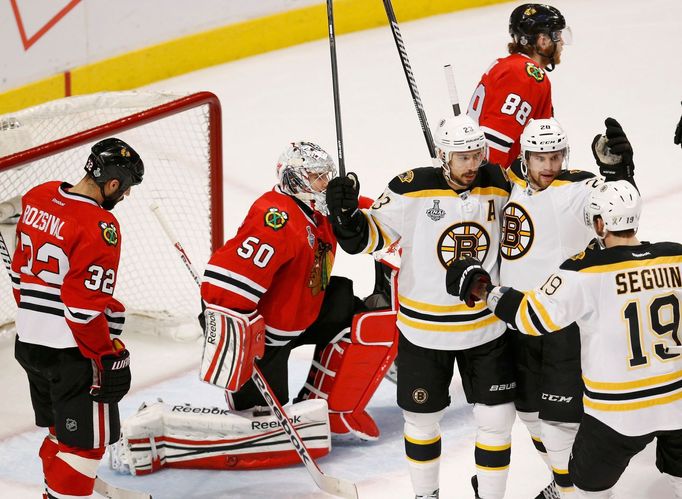 Boston Bruins' Chris Kelly (C) celebrates his goal with teammates Daniel Paille and Tyler Seguin (R) on Chicago Blackhawks goalie Corey Crawford (2nd L) and Michal Rozsiv