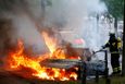 Hasič hasí hořící auto v Hamburku.