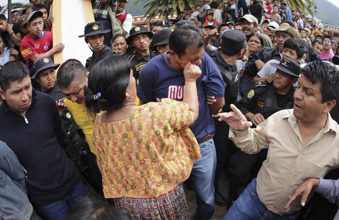 A woman punches a man who was accused of theft in Tactic, in Alta Verapaz region, about 189km (117 miles) from Guatemala City, September 13, 2012. The local community tied up and beat four men who were accused of theft in the aftermath of a school killing, which had occurred on Wednesday. The man, who had entered a classroom and killed two children, ages 8 and 13, with a machete, was lynched and burnt alive by a mob,local media reported. REUTERS/Jorge Dan Lopez (GUATEMALA - Tags: CRIME LAW SOCIETY) Published: Zář. 13, 2012, 6:04 odp.