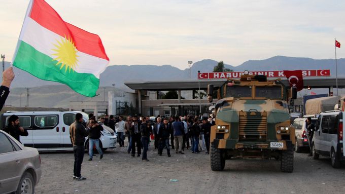 Turečtí vojáci doprovázejí vozidla kurdských bojovníků - pešmergů -, kteří míří z Iráku do severosyrského Kobani.
