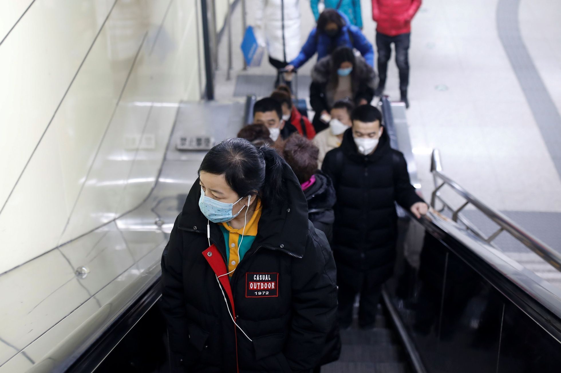 Lidé s rouškami v metru v Beijingu