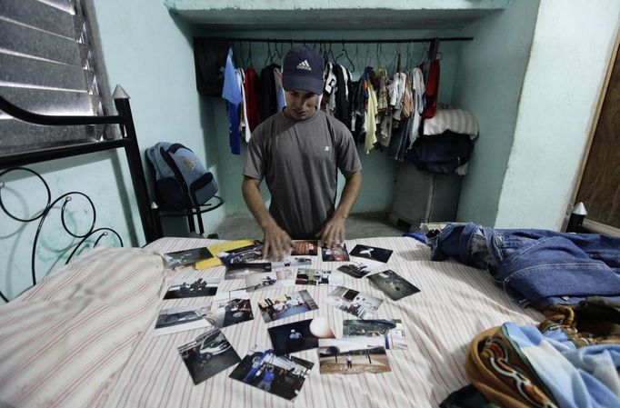 Luis Salgado, nicknamed Chucho, displays pictures of his father Jesus Salgado at his home in the village of Sagua La Grande in central Cuba, March 3, 2013. Chucho was granted a U.S. visa based on his father's status as legal resident in Texas, and he was reunited in Miami with his father, who had escaped Cuba on a frail boat ten years earlier. The Salgados are among many Cubans taking advantage of Cuba's new travel policy in place since last January, which allows citizens to leave the country with just a passport and no need for much-hated exit visas required since 1961. Picture taken March 3, 2013. REUTERS/Desmond Boylan (CUBA - Tags: POLITICS SOCIETY TPX IMAGES OF THE DAY) Published: Dub. 11, 2013, 1:12 odp.