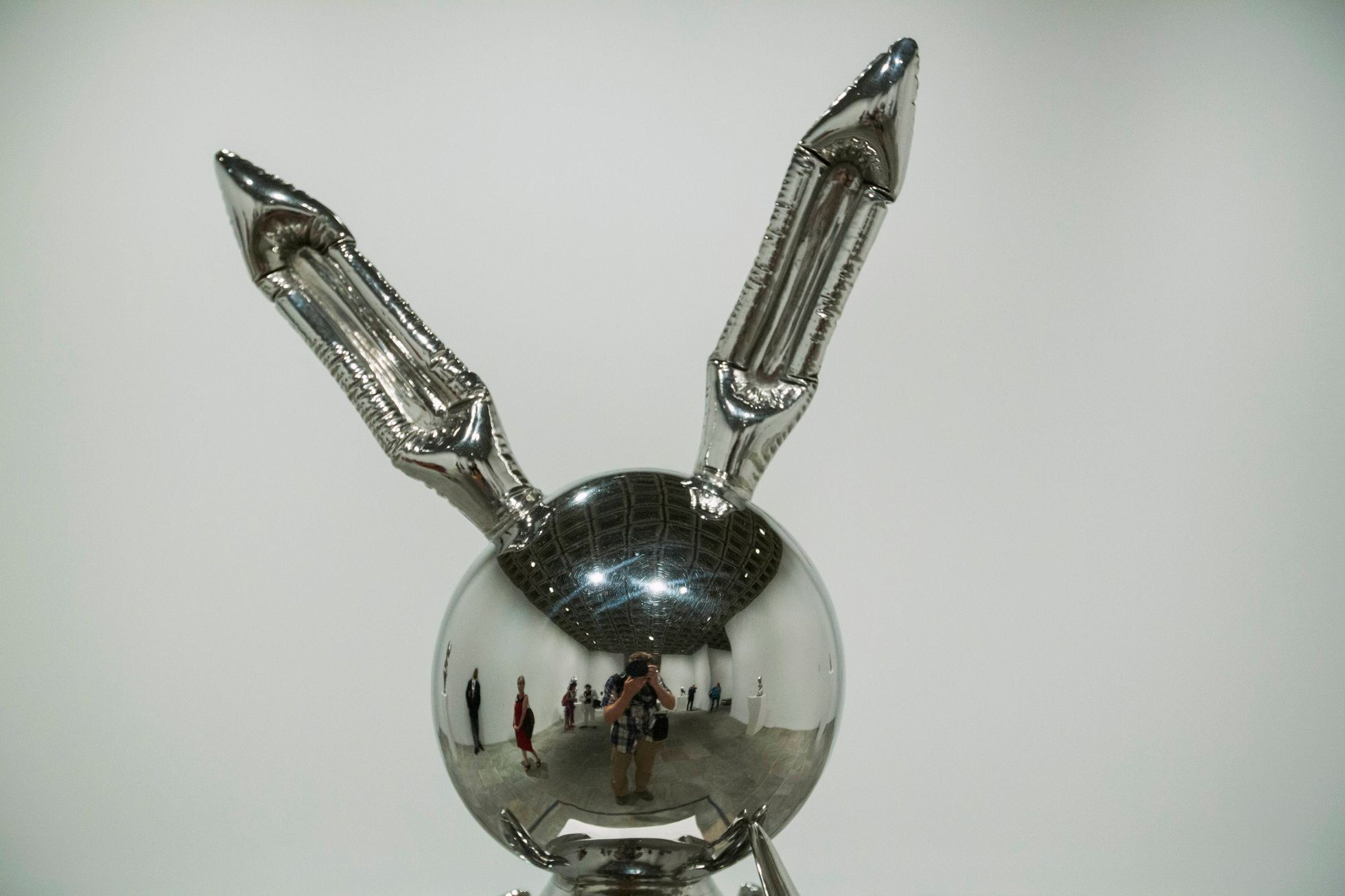 Photographer Lucas Jackson is reflected in the sculpture Rabbit during a media preview before the opening of a Jeff Koons retrospective at the Whitney Museum of American Art in New York
