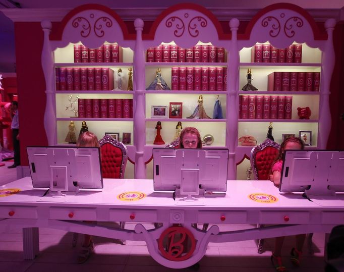 Six years old Lara (C) plays with a computer inside a "Barbie Dreamhouse" of Mattel's Barbie dolls in Berlin, May 16, 2013. The life-sized house, covering about 1,400 square metres offers visitors to try on Barbie's clothes in her walk-in closet, tour her living room and her kitchen. REUTERS/Fabrizio Bensch (GERMANY - Tags: ENTERTAINMENT SOCIETY) Published: Kvě. 16, 2013, 11:04 dop.