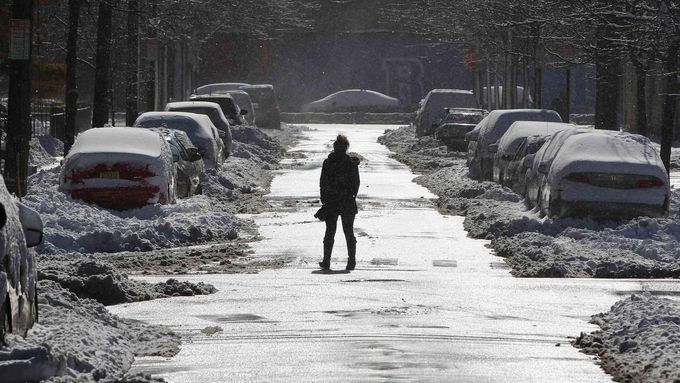 A woman crosses a street cleared of snow in Hoboken, New Jersey, February 9, 2013. A blizzard pummelled the Northeastern United States, killing at least one person, leavi