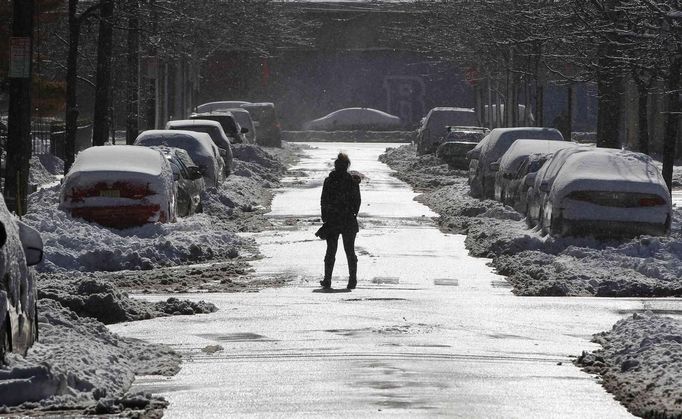 A woman crosses a street cleared of snow in Hoboken, New Jersey, February 9, 2013. A blizzard pummelled the Northeastern United States, killing at least one person, leaving hundreds of thousands without power and disrupting thousands of flights, media and officials said. REUTERS/Gary Hershorn (UNITED STATES - Tags: ENVIRONMENT) Published: Úno. 10, 2013, 12:12 dop.