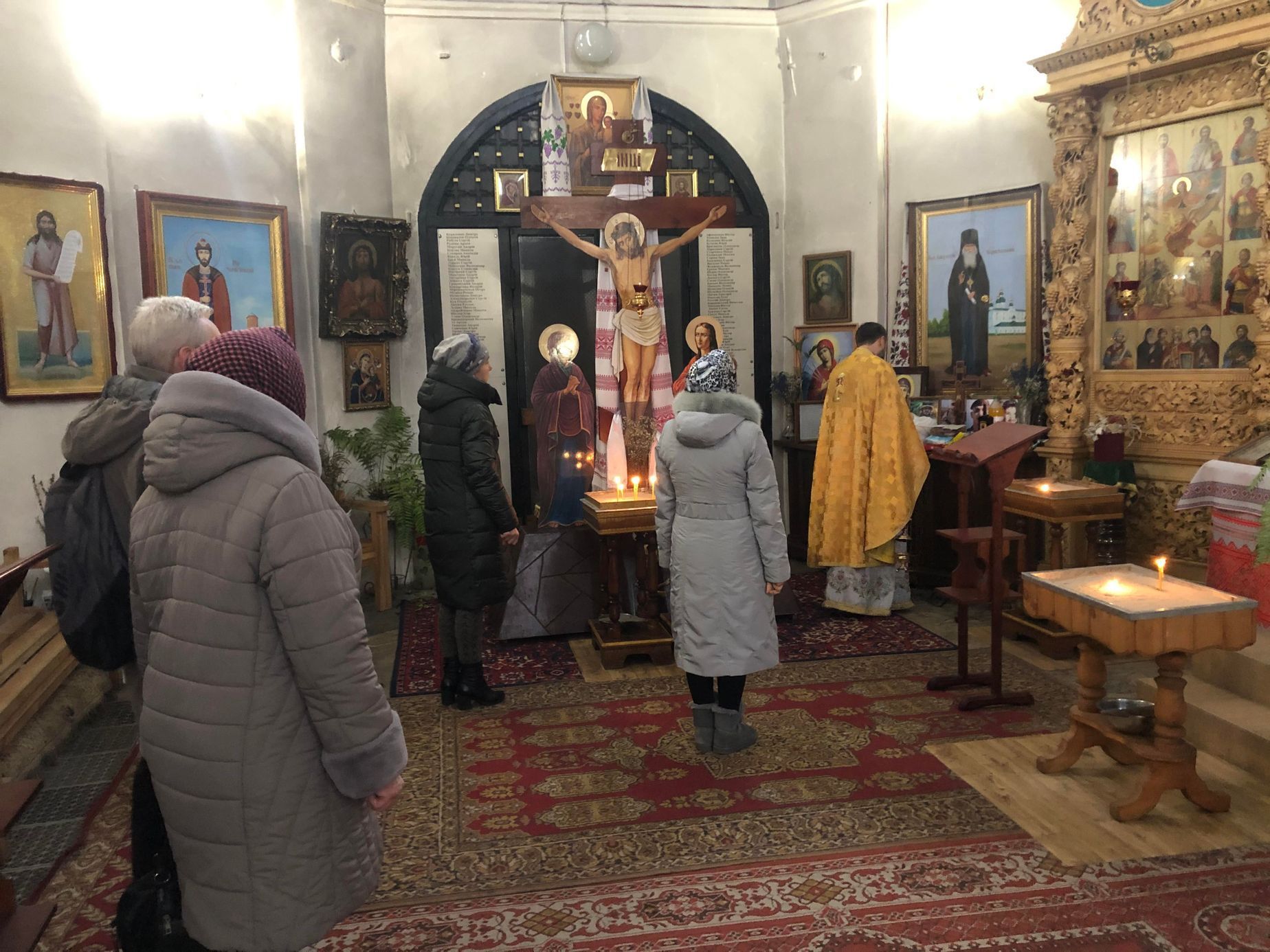 Panychida za zemřelé vojáky v pravoslavném kostele v Černihivu. Za křížem v pozadí jsou seznamy obětí z města a okolí od vypuknutí války v roce 2014.
