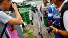 Williams Formula One driver Felipe Massa of Brazil walks off the track after crashing with his car in the first corner after the start of the German F1 Grand Prix at the