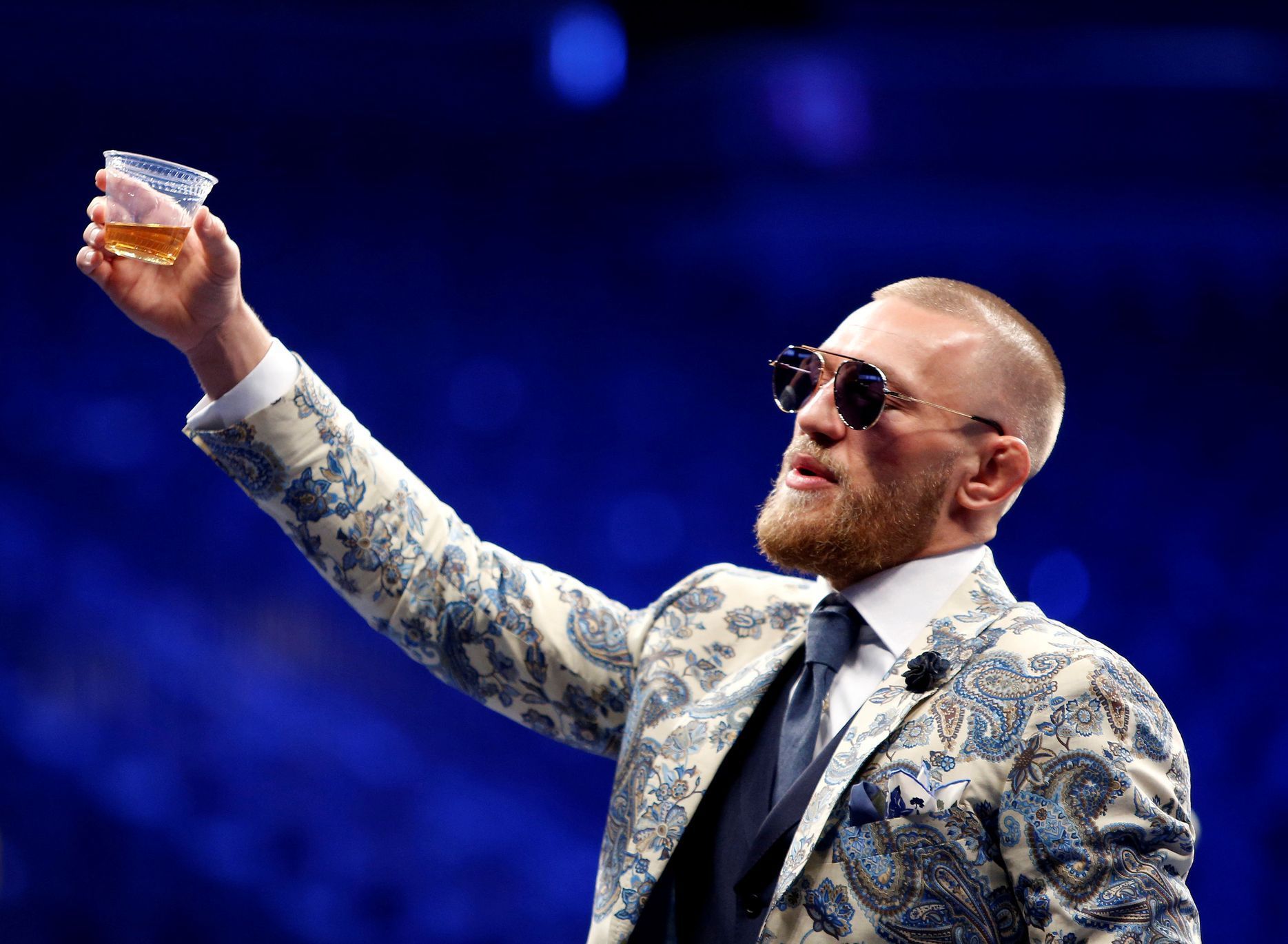 FILE PHOTO: UFC lightweight champion Conor McGregor of Ireland raises a cup of Irish whiskey during post-fight news conference at T-Mobile Arena in Las Vegas