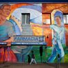 Man walks past a mural in the Echo Park area of Los Angeles, home to many Mexican and Central American migrants, in California