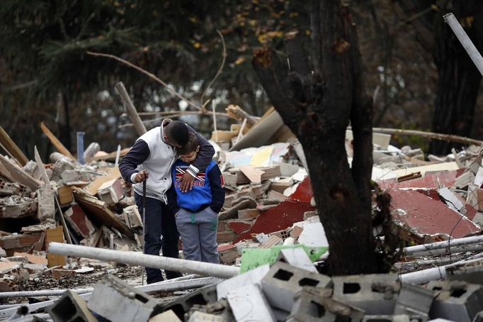 Vicente Gabarri Valdes tries to console his nephew Saul as he stands amidst the remains of his home after it was demolished at the Spanish gypsy settlement of Puerta de Hierro, in the outskirts of Madrid November 20, 2012. Fifty-four families have been living in Puerta de Hierro, on the banks of the Manzanares river for over 50 years. Since the summer of 2010, the community has been subject to evictions on the grounds that the dwellings are illegal. Families, whose homes have been demolished, move in with relatives whose houses still remain while the debris keeps piling up around them as more demolitions take place. REUTERS/Susana Vera (SPAIN - Tags: CIVIL UNREST BUSINESS CONSTRUCTION) Published: Lis. 20, 2012, 4:52 odp.