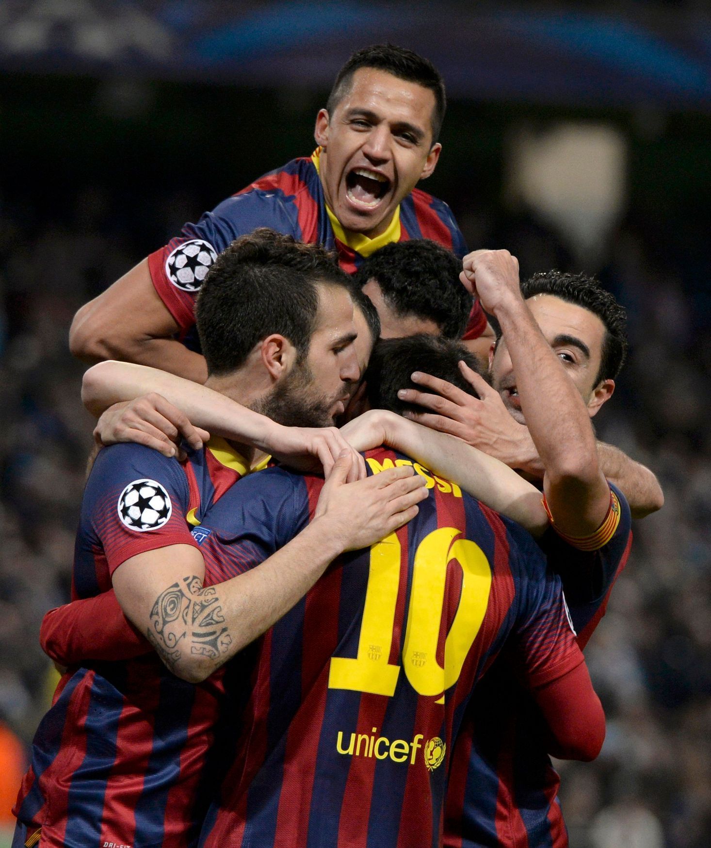 Barcelona players celebrate Lionel Messi's penalty against Manchester City during their Champions League round of 16 first leg soccer match at the Etihad Stadium in Manchester