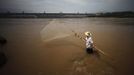 A man fishes at the Yangtze River near the Three Gorges dam in Yichang, Hubei province in this August 9, 2012 file photo. China relocated 1.3 million people during the 17 years it took to complete the Three Gorges dam. Even after finishing the $59 billion project last month, the threat of landslides along the dam's banks will force tens of thousands to move again. It's a reminder of the social and environmental challenges that have dogged the world's largest hydroelectric project. While there has been little protest among residents who will be relocated a second time, the environmental fallout over other big investments in China has become a hot-button issue ahead of a leadership transition this year. Picture taken on August 9, 2012. To match story CHINA-THREEGORGES/ REUTERS/Carlos Barria/Files (CHINA - Tags: POLITICS ENVIRONMENT BUSINESS ENERGY) Published: Srp. 22, 2012, 8:39 odp.