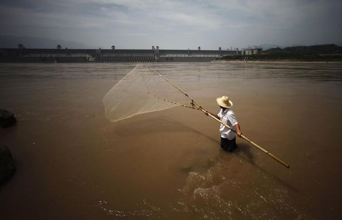 A man fishes at the Yangtze River near the Three Gorges dam in Yichang, Hubei province in this August 9, 2012 file photo. China relocated 1.3 million people during the 17 years it took to complete the Three Gorges dam. Even after finishing the $59 billion project last month, the threat of landslides along the dam's banks will force tens of thousands to move again. It's a reminder of the social and environmental challenges that have dogged the world's largest hydroelectric project. While there has been little protest among residents who will be relocated a second time, the environmental fallout over other big investments in China has become a hot-button issue ahead of a leadership transition this year. Picture taken on August 9, 2012. To match story CHINA-THREEGORGES/ REUTERS/Carlos Barria/Files (CHINA - Tags: POLITICS ENVIRONMENT BUSINESS ENERGY) Published: Srp. 22, 2012, 8:39 odp.