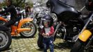 A local boy wearing a helmet poses next to a Harley Davidson motorcycle during the annual Harley Davidson National Rally in Qian Dao Lake, in Zhejiang Province May 11, 2013. Around 1,000 Harley Davidson enthusiasts from all over China met to celebrate the 5th Harley Davidson National Rally in China, as part of the company's 110-year anniversary. Major Chinese cities ban motorcycles from circulating on highways and major avenues. Meanwhile, Harley Davidson motorbikes are considered by Chinese tax authorities to be luxury items, so they are taxed at extremely high rates-- sometimes the taxes alone is equivalent to the bike's U.S. price tag. Traffic and transportation authorities have also weighed in, putting Harleys in the same category as electric bikes, horses and bicycles, meaning that they cannot be on highways and major avenues. Picture taken May 11, 2013. REUTERS/Carlos Barria (CHINA - Tags: TRANSPORT SOCIETY) Published: Kvě. 13, 2013, 11:05 odp.