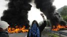 A miner stands in front of burning barricades on the A-66 motorway, on the first day of a strikes to protest against the government's spending cuts in the mining sector, in Pola de Lena, near Oviedo, northern Spain, May 23, 2012. REUTERS/Eloy Alonso (SPAIN - Tags: CIVIL UNREST BUSINESS EMPLOYMENT ENERGY POLITICS TPX IMAGES OF THE DAY) Published: Kvě. 23, 2012, 10:52 dop.