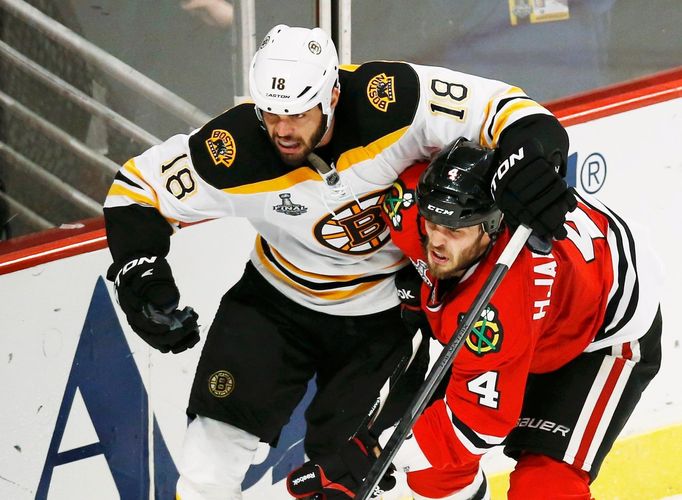 Boston Bruins' Nathan Horton (L) tries to get around Chicago Blackhawks' Niklas Hjalmarsson during the second period in Game 2 of their NHL Stanley Cup Finals hockey seri