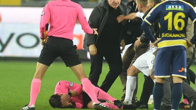 Sudí Halil Umut Meler leží na zemi poté, co dostal pěstí od šéfa klubu Ankaragücü (stojí nad rozhodčím) po utkání turecké ligy