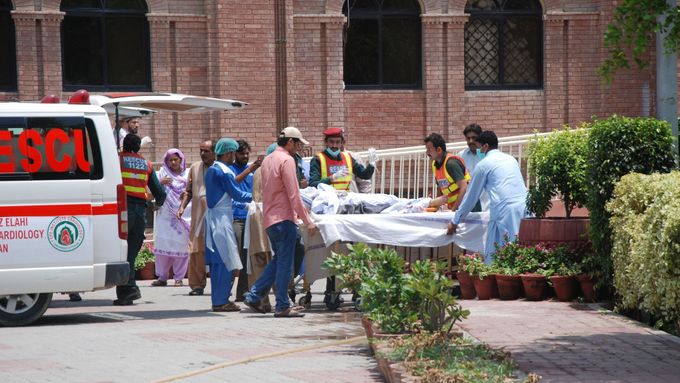 Záchranáři odvážejí raněné po explozi cisterny v Pákistánu.