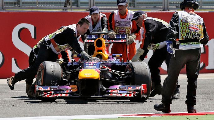 Marshalls remove the abandoned car of Red Bull Formula One driver Sebastian Vettel of Germany during the British Grand Prix at the Silverstone Race circuit, central Engla