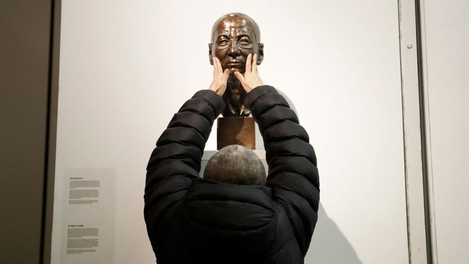 Liou Sia před bustou svého muže Liou Siao-poa v pražském Centru současného umění DOX.