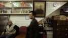 A customer walks past a portrait of the founder of a snake soup shop in Hong Kong January 30, 2013. There are scores of people in Hong Kong who have through generations tamed snakes to make soup out of them, a traditional cuisine believed to be good for the health. Yet the people behind providing fresh snakes for the savoury meal thought to speed up the body's blood flow and keep it strong in the cold winter months may be doomed, with young people increasingly reluctant to take on a job they see as hard and dirty. Picture taken January 30, 2013. REUTERS/Bobby Yip (CHINA - Tags: ANIMALS FOOD SOCIETY) Published: Úno. 7, 2013, 2:01 odp.