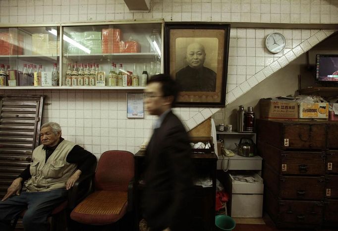 A customer walks past a portrait of the founder of a snake soup shop in Hong Kong January 30, 2013. There are scores of people in Hong Kong who have through generations tamed snakes to make soup out of them, a traditional cuisine believed to be good for the health. Yet the people behind providing fresh snakes for the savoury meal thought to speed up the body's blood flow and keep it strong in the cold winter months may be doomed, with young people increasingly reluctant to take on a job they see as hard and dirty. Picture taken January 30, 2013. REUTERS/Bobby Yip (CHINA - Tags: ANIMALS FOOD SOCIETY) Published: Úno. 7, 2013, 2:01 odp.