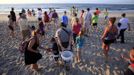 Tourists walk to the surf after watching an inventory of a hatched nest at Myrtle Beach State Park in Myrtle Beach, South Carolina August 4, 2012 . Inventories are taken three days after the nests hatch. Turtle volunteers walk the area's beaches along South Carolina's coast daily during the nesting season, looking for signs of turtle activity and keeping tabs on the progress of the endangered species of turtles that lay their eggs along the coast. Photo taken August 4, 2012. REUTERS/Randall Hill (UNITED STATES - Tags: ANIMALS ENVIRONMENT) Published: Srp. 21, 2012, 12:53 odp.